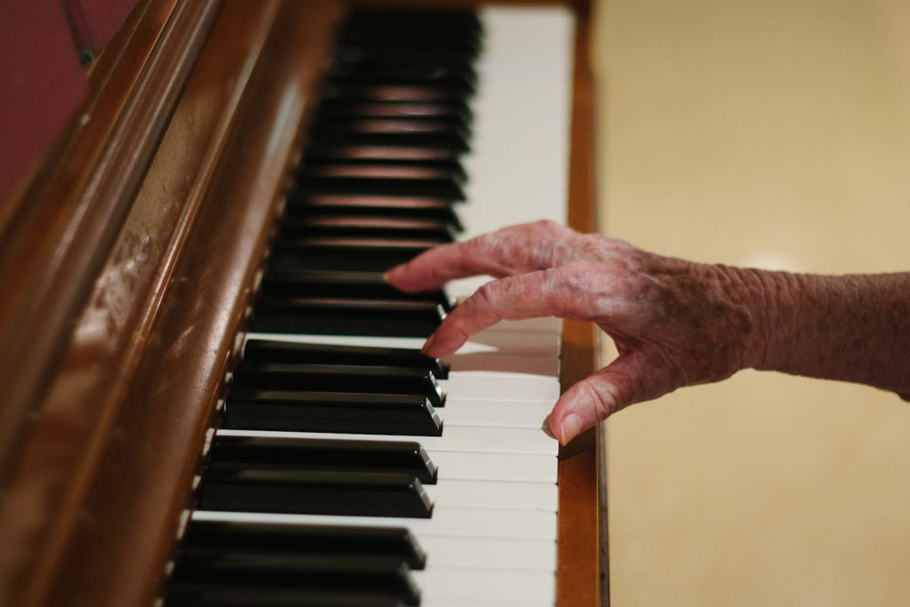 A woman playing the piano at a respite care facility