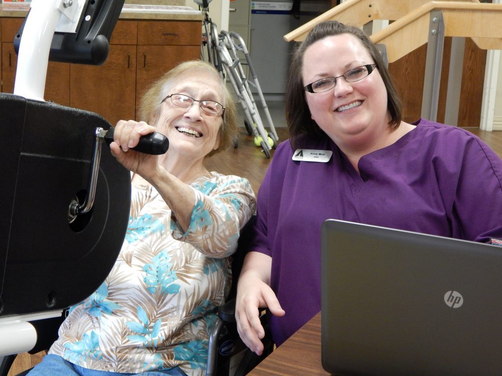 A woman smiles with a nurse at a skilled nursing facility