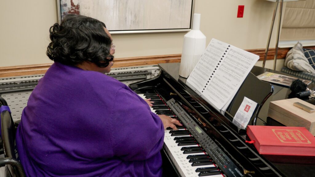A woman playing the piano at a skilled nursing facility nursing home