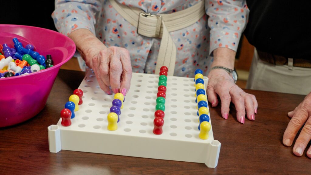 A woman in short term care physical therapy being assisted by a nurse